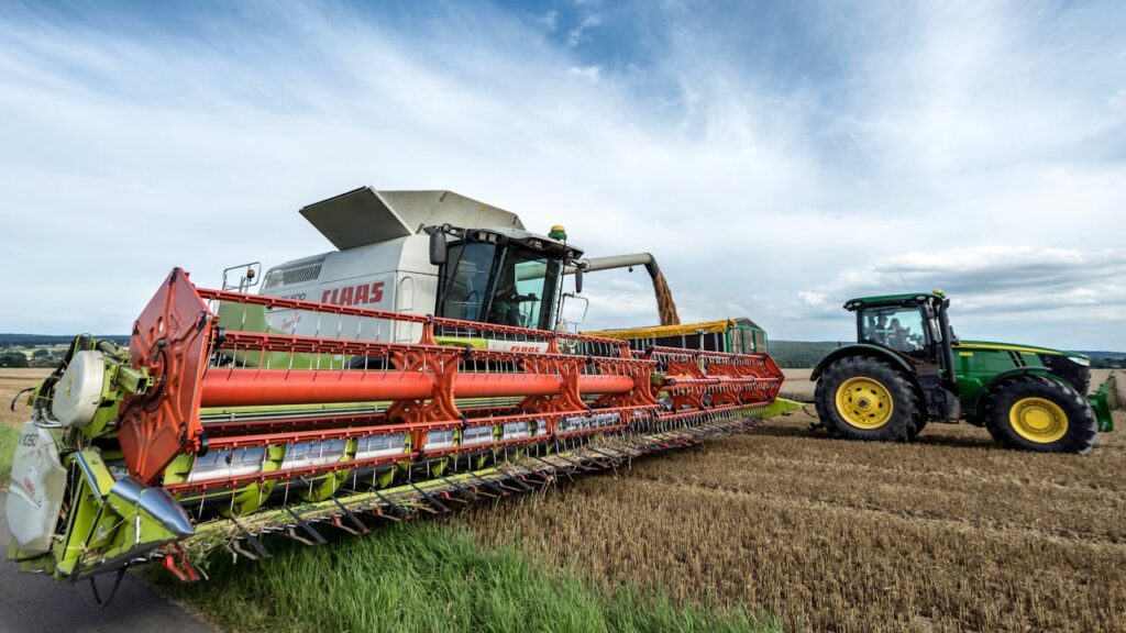 A combine harvester and tractor in action on a wheat field in Höxter, Germany.